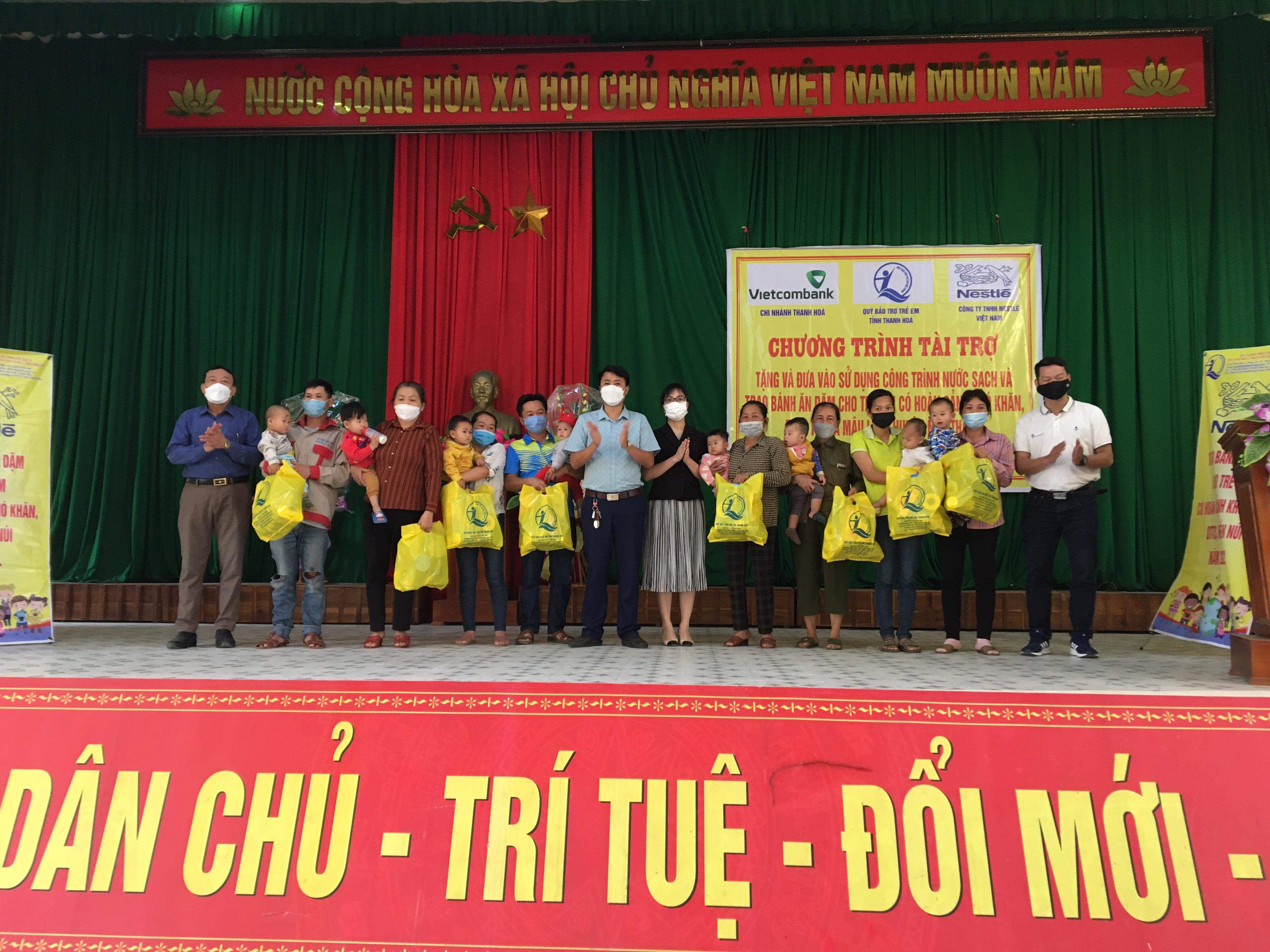 Đại diện Quỹ BTTTE, Vietcombank Thanh Hóa, Nestlé Việt Nam và lãnh đạo UBND huyện Như Thanh trao bánh ăn dặm cho trẻ em