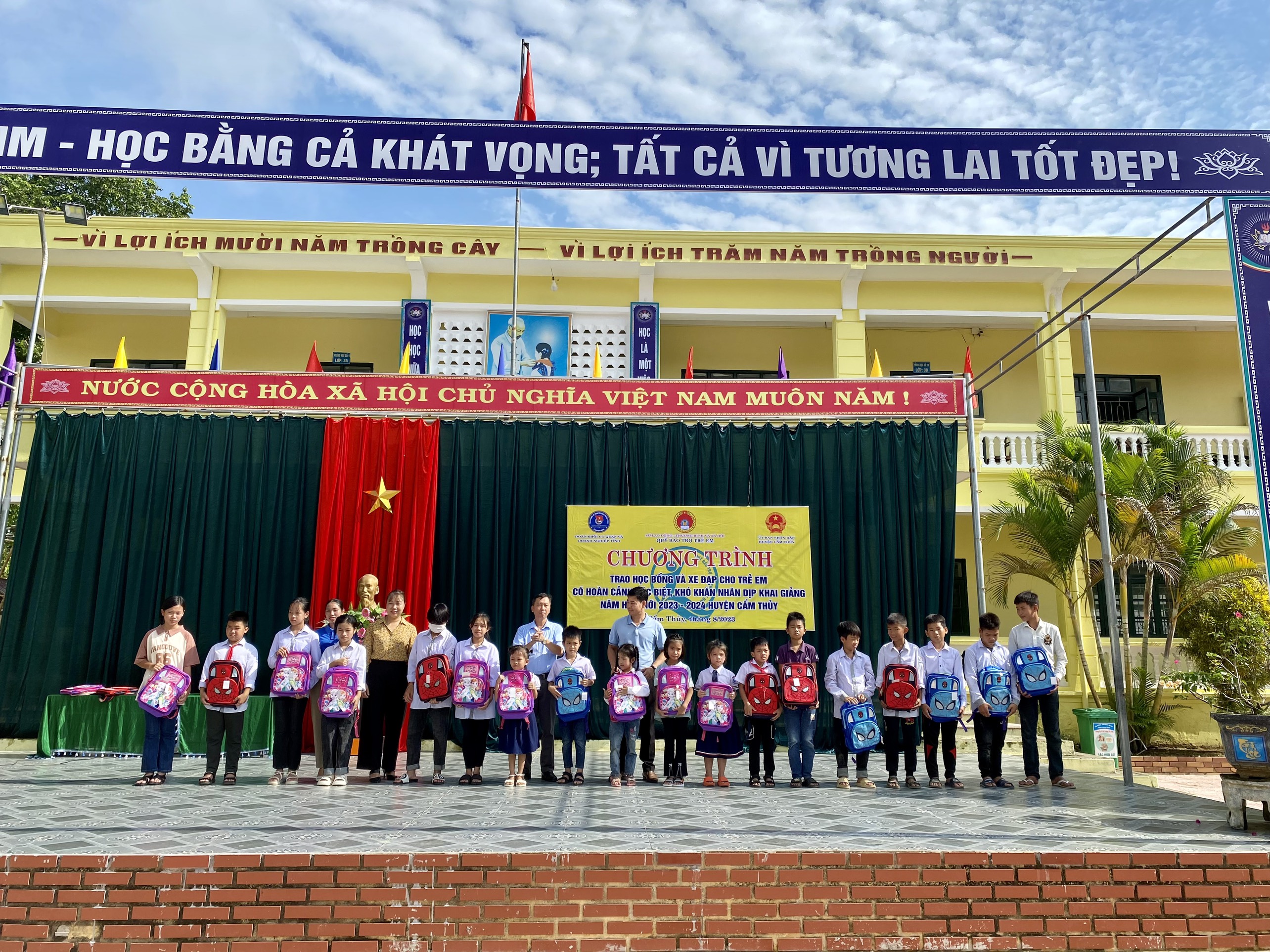 Lãnh đạo Huyện đoàn, Ban Giám hiệu các trường trao ba lô, đồ dùng học tập cho trẻ em.