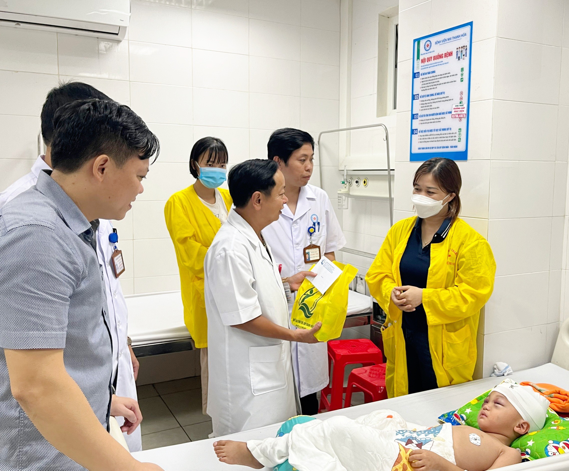 Đồng chí Hà Hoàng Minh, Phó Giám đốc Bệnh viện Nhi Thanh Hóa trao quà cho trẻ em bệnh nhi tại giường bệnh.