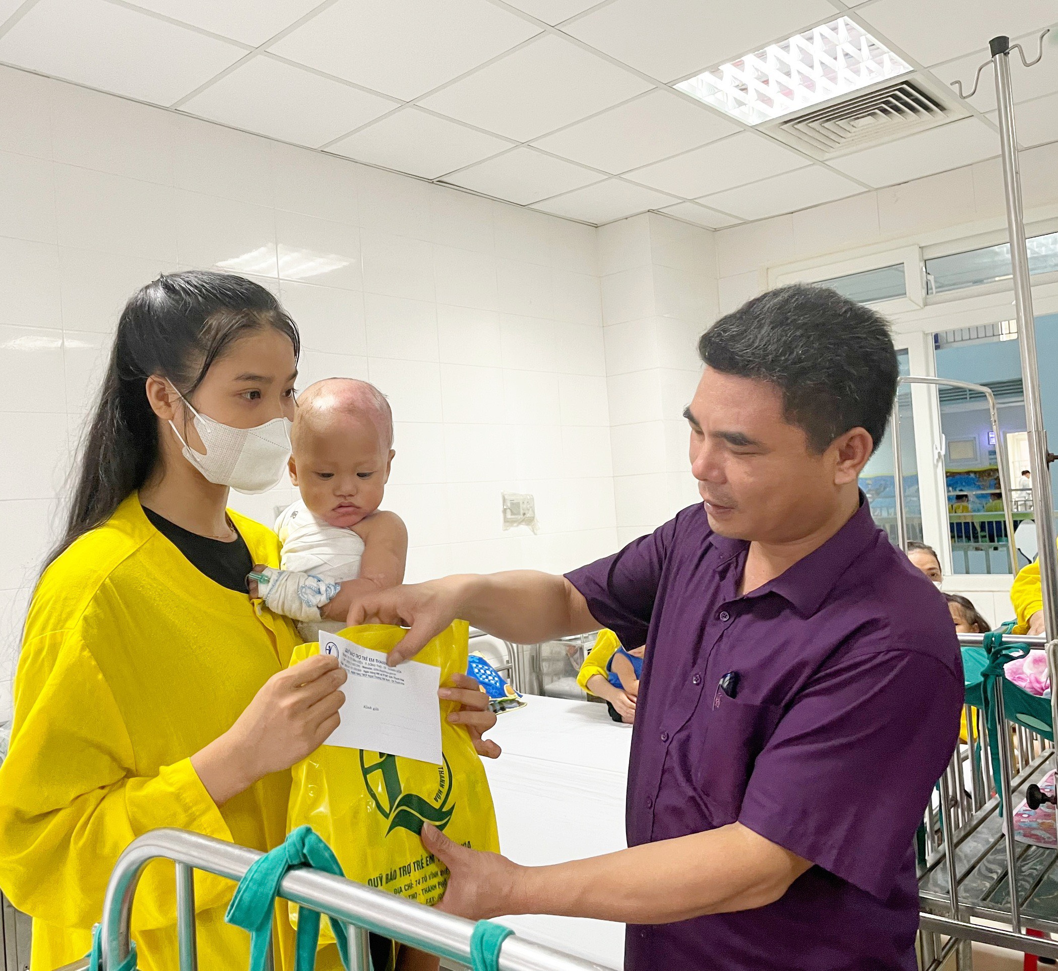 Đồng chí Vũ Huy Vượng, Trưởng phòng Trẻ em và Bình đẳng giới trao quà cho trẻ em bệnh nhi tại giường bệnh.