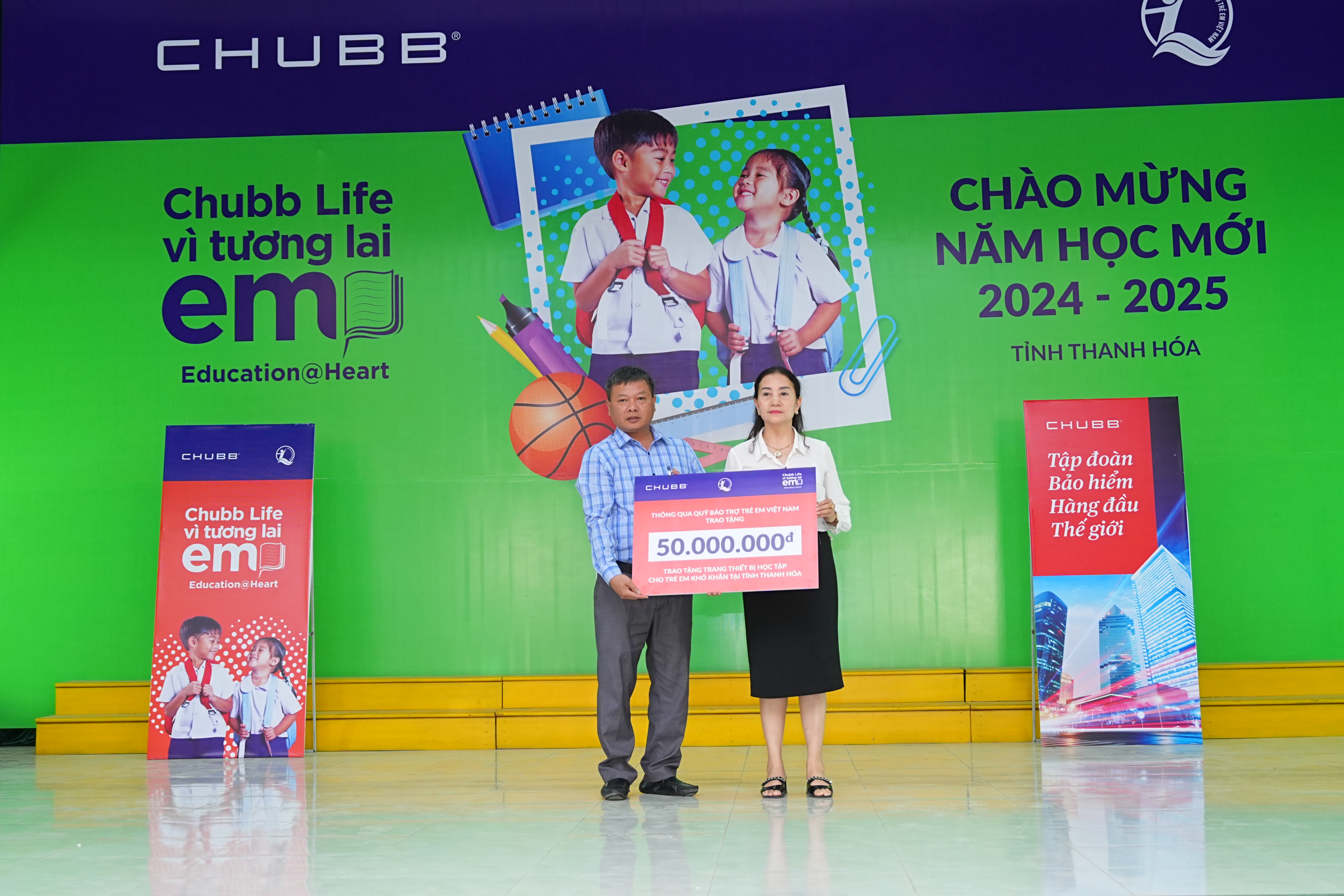 Đại diện lãnh đạo Chubb Life Việt Nam trao biển tượng trưng máy tính cho trẻ em xã Nga Trường.