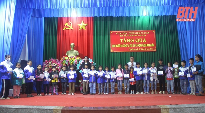Thứ trưởng Bộ Lao động - Thương binh và Xã hội Nguyễn Bá Hoan và Giám đốc Sở Lao động - Thương binh và Xã hội Vũ Thị Hương trao quà cho các cháu học sinh có hoàn cảnh khó khăn trên địa bàn huyện Nga Sơn (ảnh Nguyễn Lương).