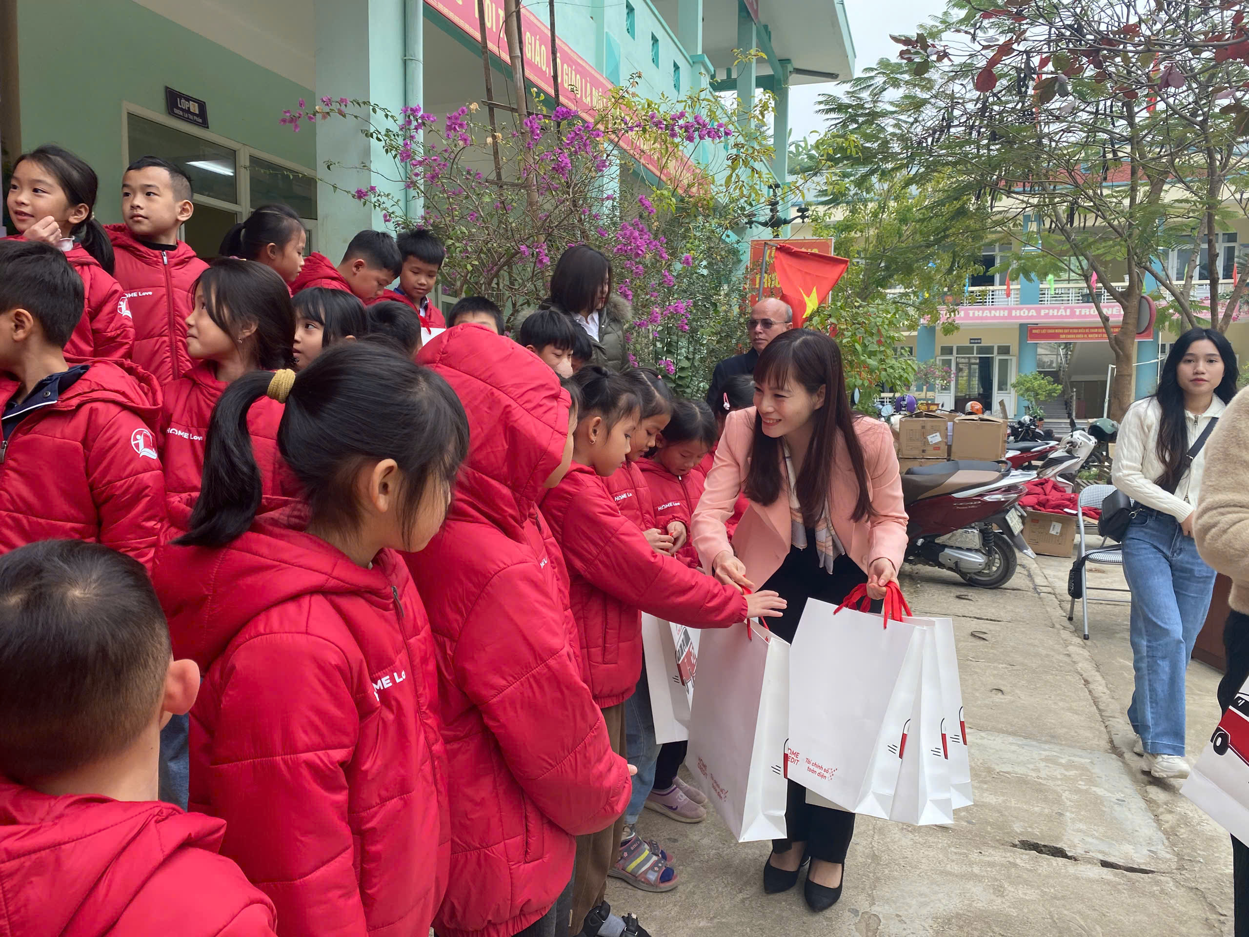 Đại diện Quỹ BTTE Việt Nam trao áo ấm đồng phục cho học sinh Trường Tiểu học xã Tam Chung.