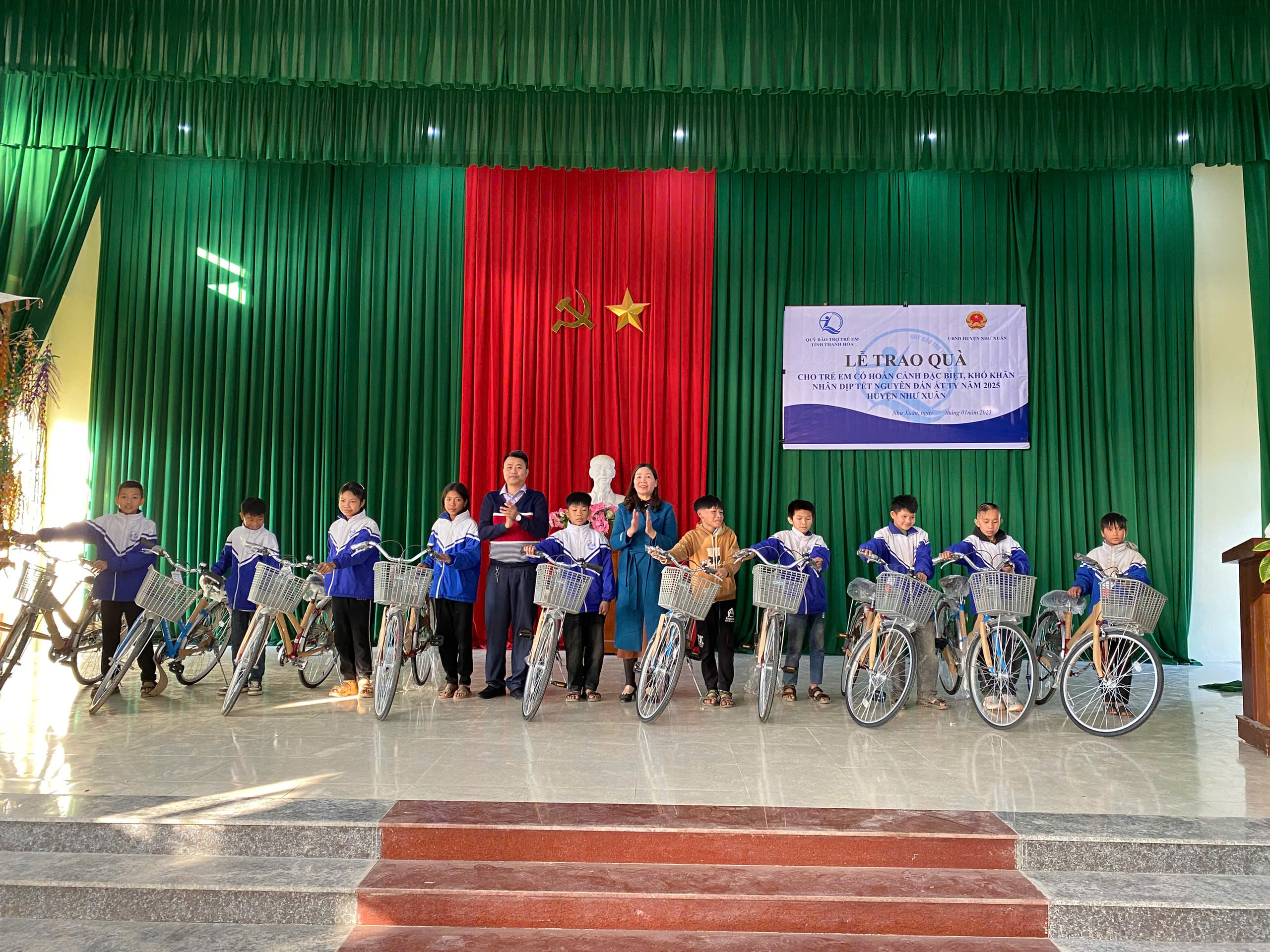 Quỹ BTTE tỉnh và đại diện phòng LĐTBXH Như Xuân trao xe đạp cho trẻ em
