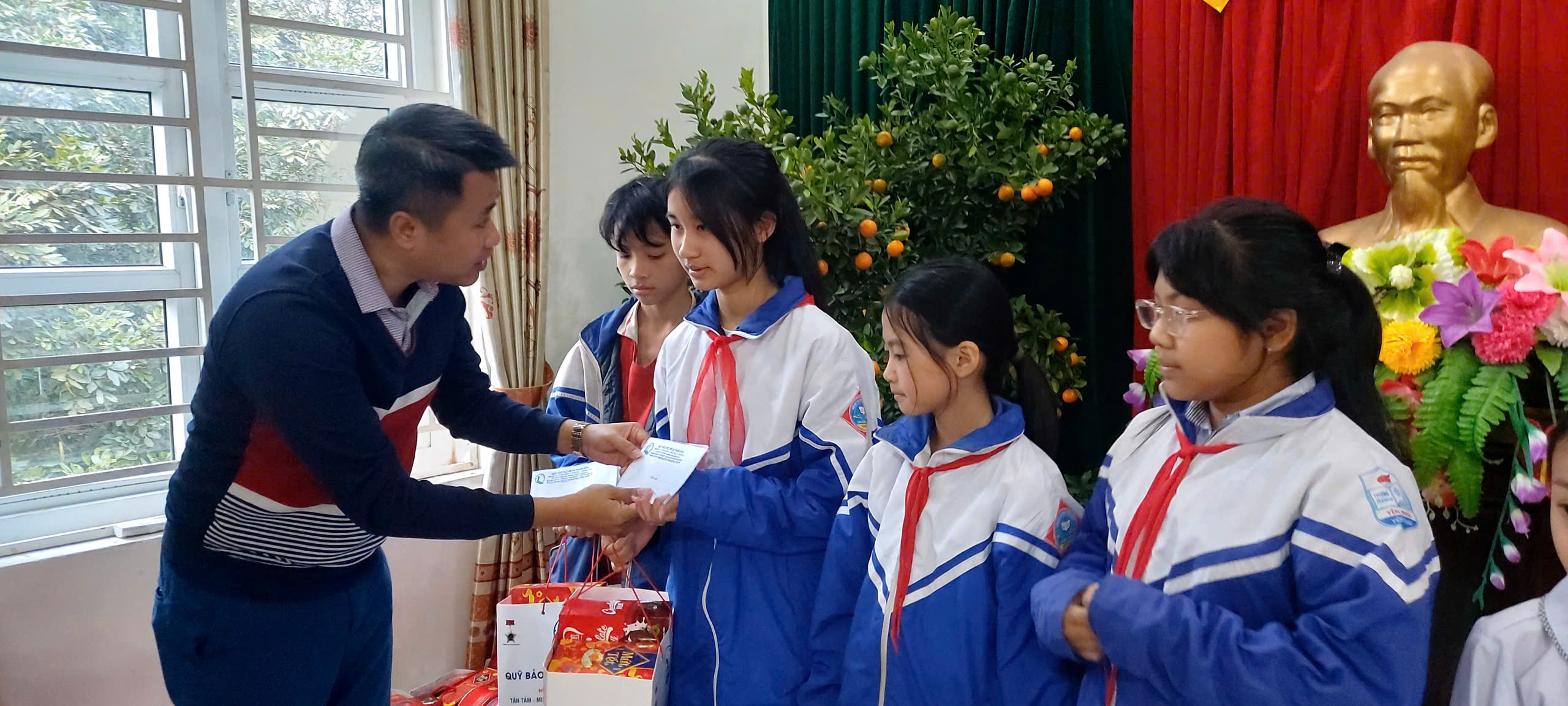 Đồng chí Lại Thế Quảng - Giám đốc Quỹ BTTE tỉnh trao quà cho trẻ em.