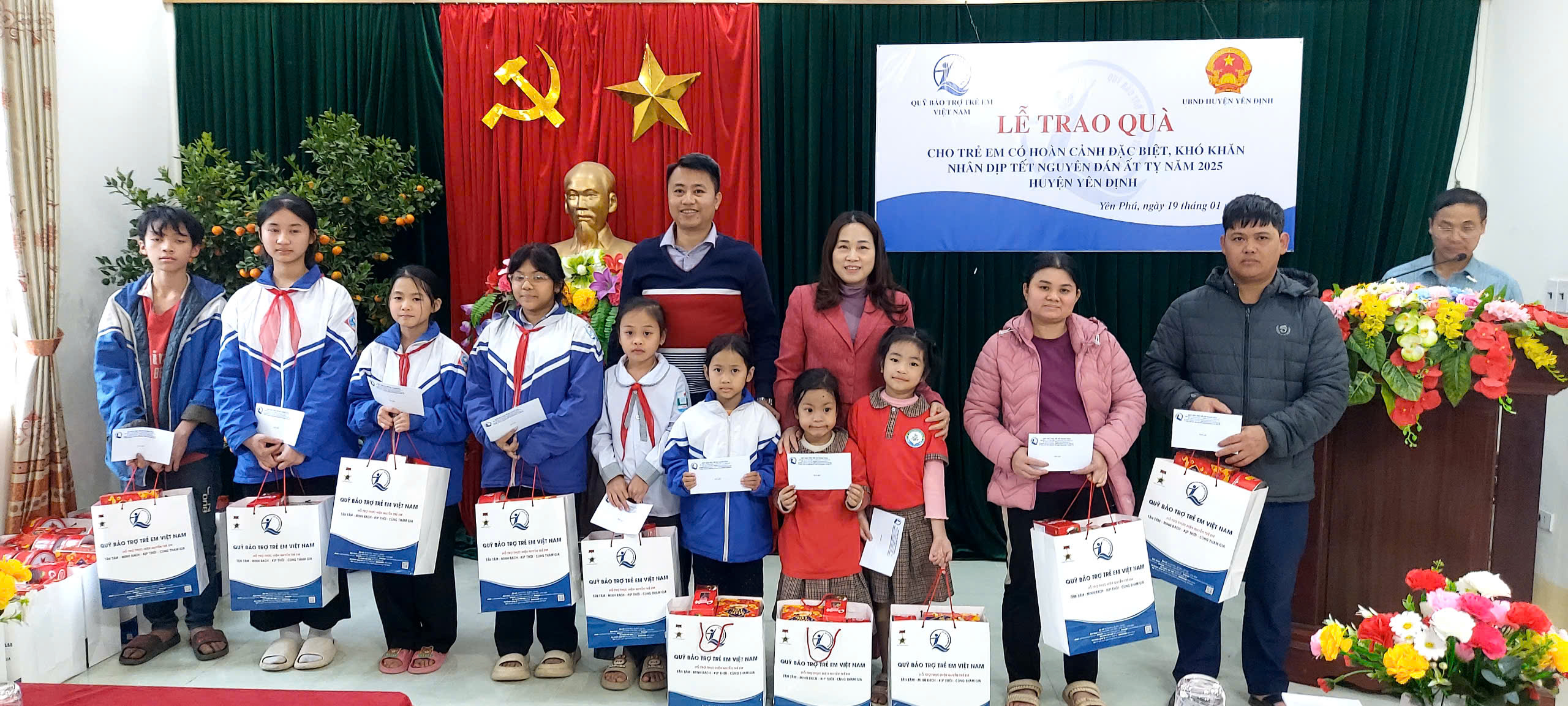 Lãnh đạo Quỹ BTTE tỉnh và Trưởng phòng LĐTBXH huyện Yên Định trao quà cho trẻ em.