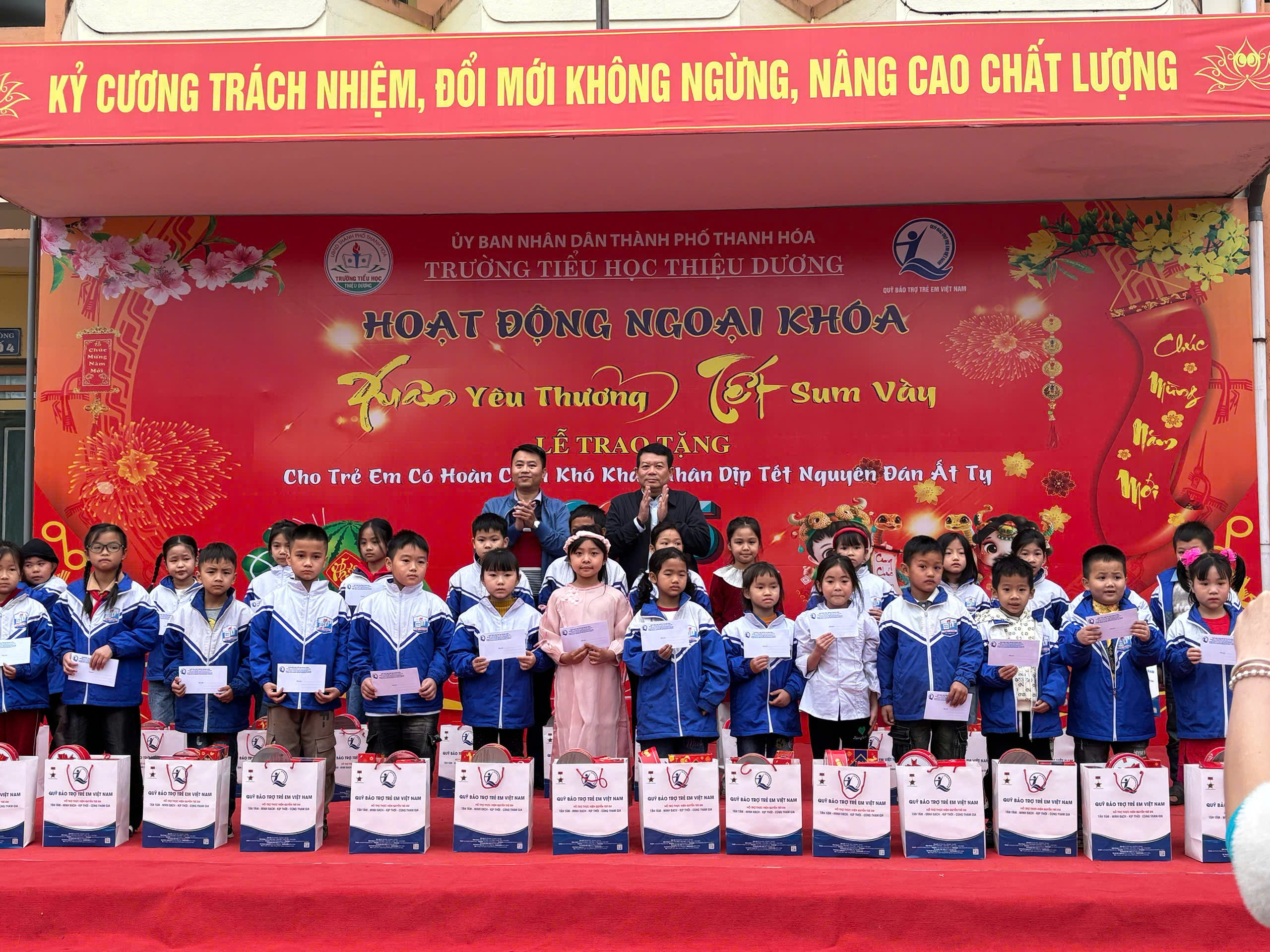 Lãnh đạo Quỹ BTTE tỉnh và lãnh đạo UBND phường Thiệu Dương trao quà cho trẻ em.
