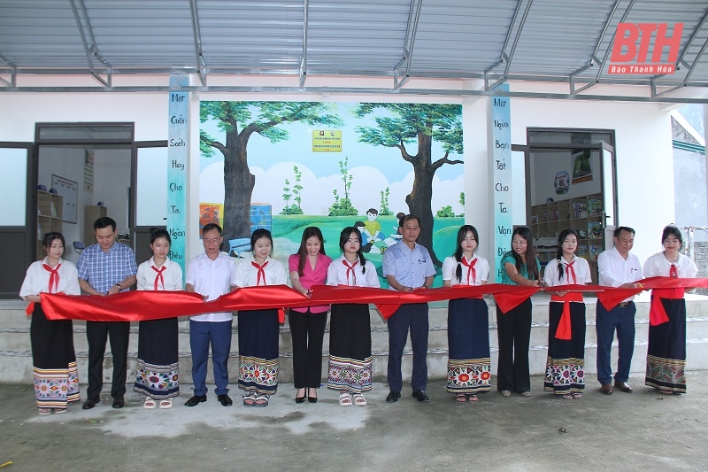 Các đại biểu thực hiện nghi thức khánh thành công trình xây dựng và mua sắm trang thiết bị thư viện Trường THCS Vạn Xuân.